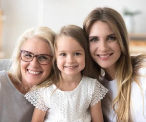 Una nonna, una madre e una figlia sorridono insieme